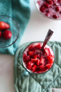 Beyaz masa izole edilmiş arka planda lezzetli çilekli panna cotta ile cam. Lezzetli İtalyan tatlısı.