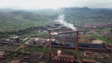 Endüstriyel fabrika kirliliği atmosferi, şehrin yakınındaki bacalardan gelen büyük dumanlar, insansız hava araçlarından ateş