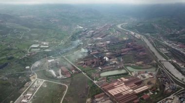 Endüstriyel fabrika kirliliği atmosferi, şehrin yakınındaki bacalardan gelen büyük dumanlar, insansız hava araçlarından ateş