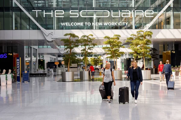 Germany, Frankfurt, August 16, 2019: Passengers walking in the hallway of Frankfurt Airport with the Squaire business center. This impressive building makes an incredible first impression. — Stock Photo, Image
