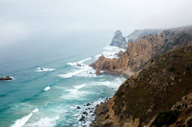 Kayalıklar Atlantik Okyanusu' nda sisle kaplıdır, Portekiz' in Cascais kenti yakınlarındaki Cabo da Roca' da doğal bir manzara. Avrasya kıtasının en batı pelerini.