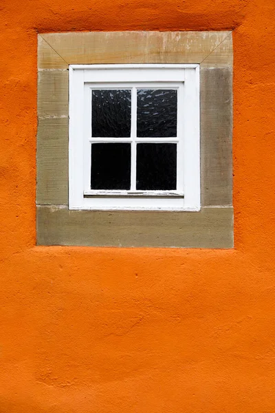 Δημιουργική εικόνα ενός όμορφου παλιού παραθύρου με ξύλινο πλαίσιο πάνω σε έναν πορτοκαλί πέτρινο τοίχο. Κάθετη — Φωτογραφία Αρχείου