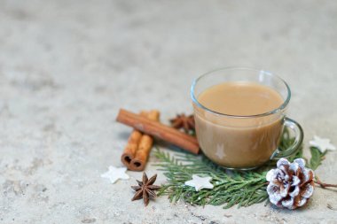 Bir fincan kahve, çam kozalağı, tarçın çubukları ve selvi ağacının yeşil dalında anason yıldızları. Yeni yılın kahvaltı tasarımı. Seçici odak, boşluğu kopyala