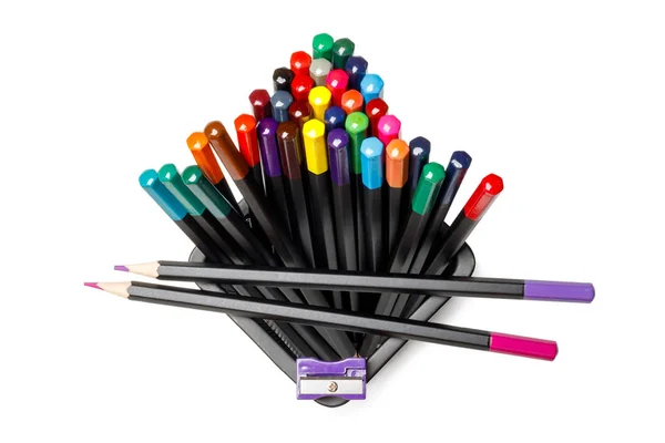 Colored pencils in a black shell and a purple sharpener. View from above. Isolated. — Stock Photo, Image