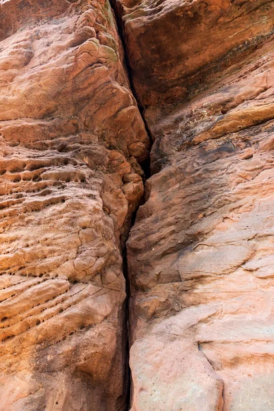 Une grosse fissure dans la roche. Rochers de grès rouge et orange avec traces de destruction, érosion. Texture abstraite de pierre . — Photo
