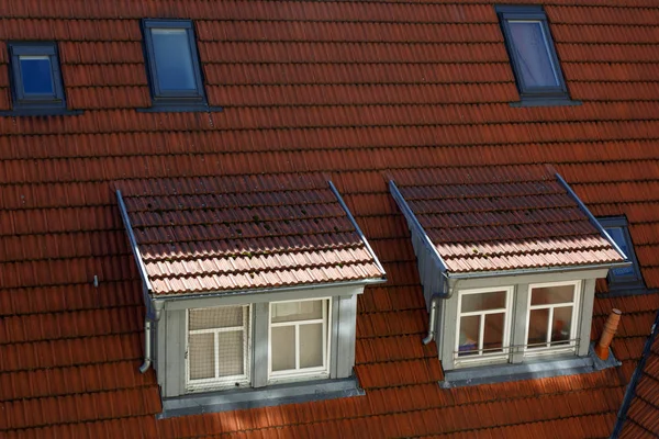 Roofs of European historic houses with skylights and orange tiles — Stock Photo, Image