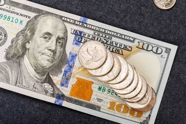 Hundred dollar bill of the USA and several coins in denominations of five cents. Franklin does not approve of the poverty concept