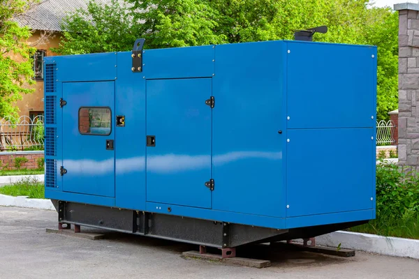 Diesel generator for emergency power supply at the wall of a medical center against the backdrop of green trees in fine weather. — Stock Photo, Image