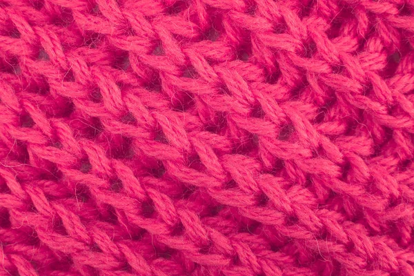 El primer plano del patrón de punto de lana. El primer plano del fragmento de la bufanda tejida caliente. Hilados gruesos de lana roja . — Foto de Stock