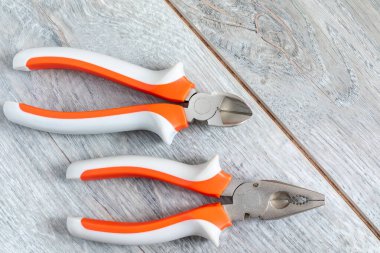 Gri kaplamalı iki farklı pense ve yan bıçak seti. Tamir, dekorasyon ve inşaat teması. Yakın plan, kopyalama alanı.