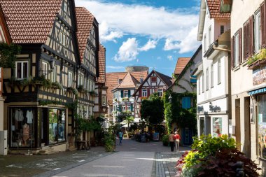 Güneşli bir yaz gününde tarihi, ortaçağ yarım keresteli evleri. Küçük, eski bir Alman şehrinin günlük hayatı. Besigheim, Almanya - 10 Ağustos 2019.