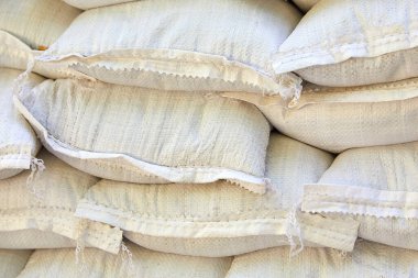 Büyük plastik torbalar içinde pirinç, şeker, mısır gevreği, depodaki kum taşımaya, teslimata ve üst üste yığılmış beyaz poşetlere hazır.