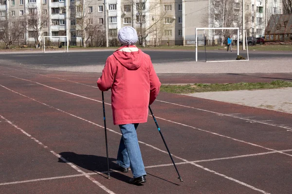 Pernas Uma Mulher Idosa Praticando Caminhada Nórdica Campo Esportivo Perto — Fotografia de Stock