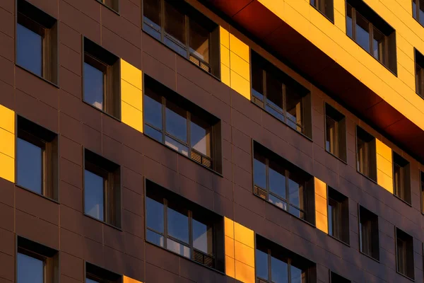 Fragment of a new elite residential building or commercial complex. Part of urban real estate. Yellow-brown modern ventilated facade with windows. — Stock Photo, Image