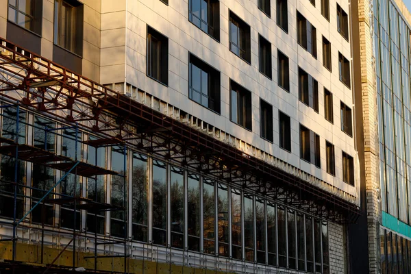 Finishing the facade of the building with a ventilated facade. A fragment of a residential building, hotel, hospital or other commercial property with glazed windows and building loess.