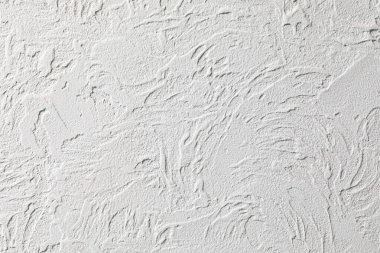 Kalkmış beyaz duvarın arka planı dekoratif alçıyla tamamlanmış. Beton duvardaki dalgalar gibi soyut çizgiler. Eski konutların ve ticari gayrimenkullerin tasarımı.