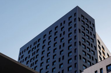 Yeni elit bir konut binasının ya da ticari bir kompleksin parçası. Şehir gayrimenkullerinin bir parçası. Pencereli, siyah, modern, havalandırmalı cephe. Çapraz düzenleme