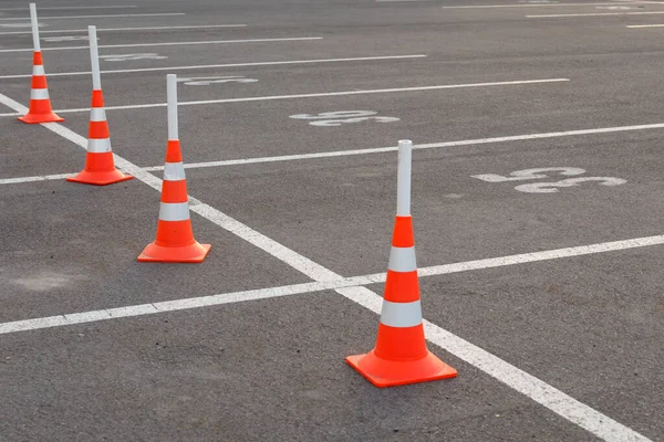 Marked Parking spaces with orange traffic cones. Symbol of restrictions, road works, attention. For publications on driving schools, traffic, and road construction