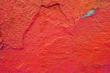 Kırık alçılı parlak kırmızı, eski bir duvar. Çatlak, çip, delik ve diğer düzensizliklerle dolu pürüzlü bir arka plan. Boşluğu kopyala