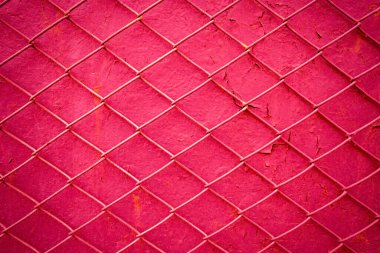 Arka plandaki metal tel ızgarada eski bir kırmızı duvarın boyası soyulmuş. Örgü dokusu, erkek özgürlüğünün sınırlanması, kadınlara bağımlılık, özgürlük eksikliği ve bağımlılık kavramı..