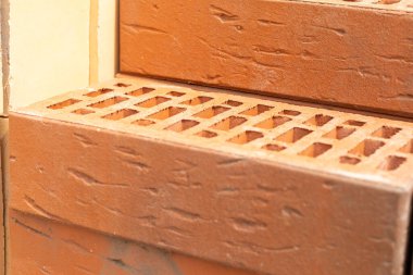 İnşaat alanında bir yığın sarı ve kahverengi tuğla. Kapat.