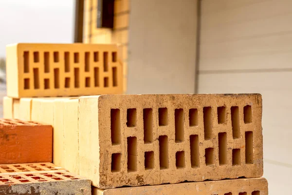 A stack of yellow and brown hollow bricks on a construction site. — Stock Photo, Image