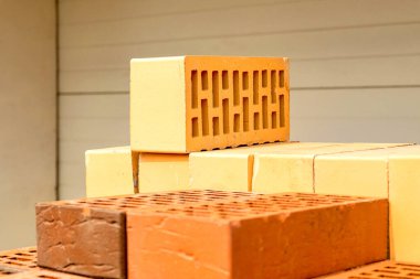 İnşaat alanında bir yığın sarı ve kahverengi tuğla..