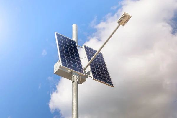 Fotovoltaik panelli çevre sokak lambası bulutlu mavi gökyüzüne karşı. Güneşten gelen alternatif enerji kavramı. Yakın plan..