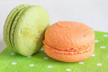 Şeftali ve şam fıstıklı kurabiye. Açık yeşil bir peçete. Makaron ya da badem kurabiyesi Fransız ya da İtalyan tatlısıdır. Yakın plan.