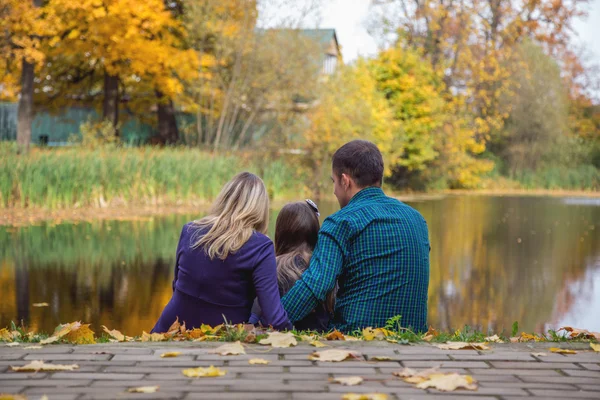 Família feliz no lago com as costas viradas — Fotografia de Stock
