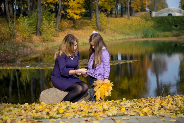 Mutter und Tochter spazieren im Herbstpark — Stockfoto