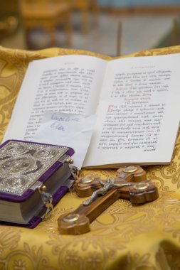 İncil ve haç. Bebek vaftiz ayini için hazırlanıyor.