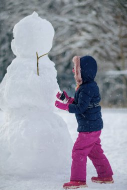 Kız kardan adam yapıyordu. Noel sezonu. Yeni yıl. Kış.