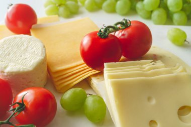 Meyve ve sebzeli peynirin çeşitliliği açık mermer arkaplanı kapatır. 