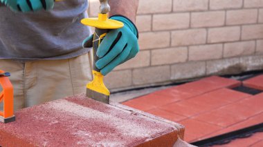 Fayans kesme endüstrisi ekipmanları. Terastaki döşemeler için döşeme kiremitleri kesen işçiler