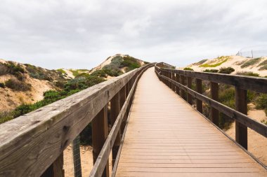 Rustik ahşap Beach Boardwalk kum tepeleri ile. Oso Flaco Gölü doğal bölgesi eyalet parkı, Kaliforniya