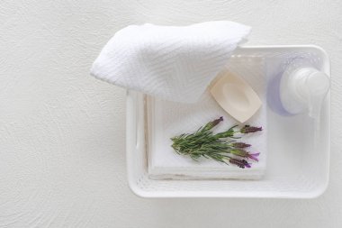 Beyaz pamuklu havlular, sabun ve lavanta çiçekleri beyaz arka planda, ürün sergisi için kopyalama alanı. Aromaterapi, spa konsepti
