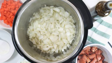 Saute chopped  onion in a multicooker. Cooking rice with meat and vegetables  in pressure multi cooker step by step, top view.