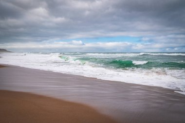Tropik plaj günbatımı. Boş kumsal ve bulutlu gökyüzü arkaplanı.