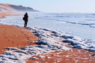 Soyut manzara. Dramatik okyanus ve sahildeki kadın silueti..