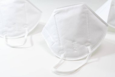 Birkaç Kn-95 koruma solunum maskesi beyaz arka planda kapanıyor. Virüs ve salgın hastalığın yayılmasını önlemek için koruyucu ağız filtresi maskesi. Hastalıklar, grip, hava kirliliği, corona virüsü konsepti