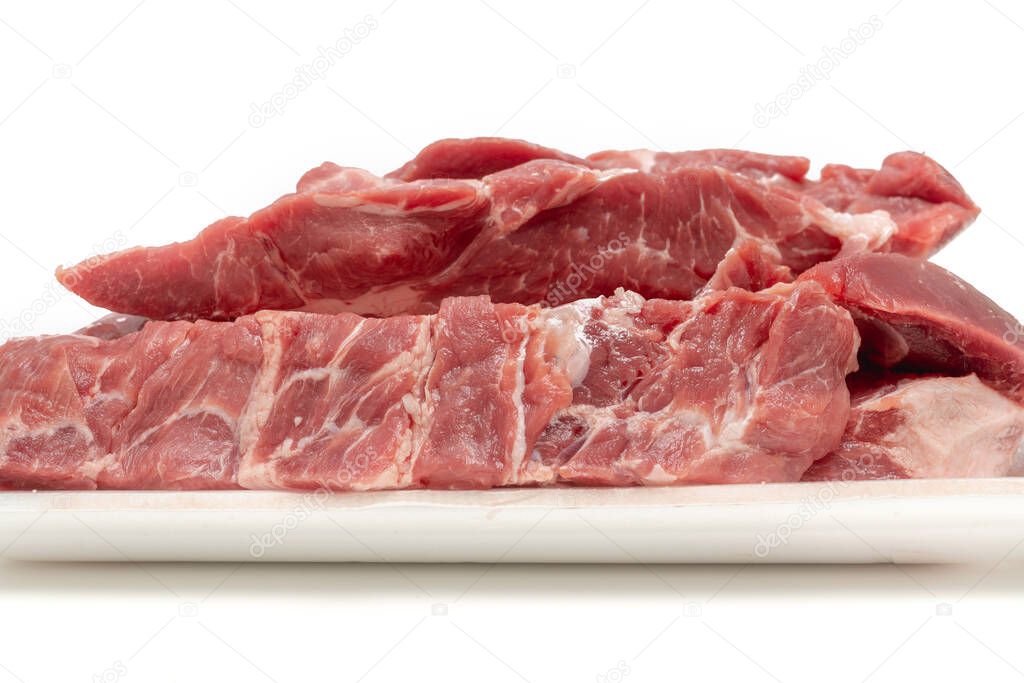 Raw pork meat cuts in white container close up isolated on white background. Fresh slices without bone