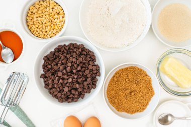 Çikolata parçacıkları ve pişirme malzemeleri mutfak masasına yakın durmalı. Çikolatalı kurabiye tarifi.