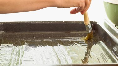 Zeytinyağı ile yağlama yaprağı. Kadın elleri, beyaz arkaplanı kapatın.