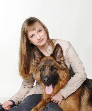 Genç kadın güzel kabarık Alman çoban köpeği beyaz arka plan karşı hugs