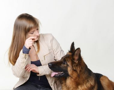 Genç kadın güzel kabarık Alman çoban köpeği beyaz arka plan karşı hugs