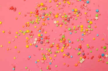 Üstten Görünüm düz renkli şeker dekor pembe kağıt üzerinde yatıyordu düzeni. Minimalist trendy arka plan.