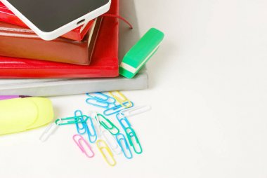 Grup okul malzemeleri, kitaplar, Günlükler, beyaz arka plan üzerinde izole cep telefonunuzla