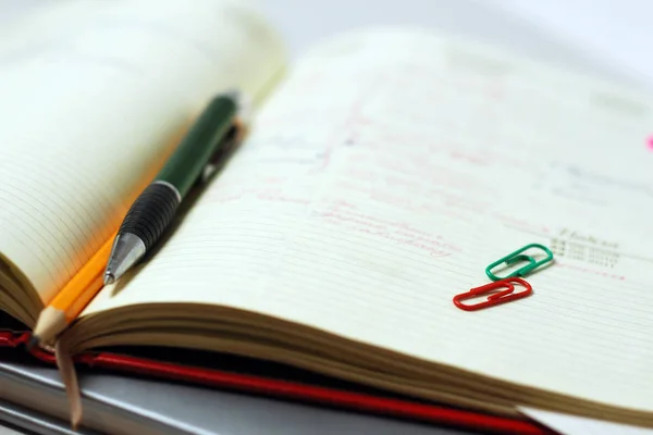 Pen en potlood op een open dagboek close-up. Zakelijke thema achtergrond — Stockfoto