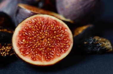 Yakın çekim resim taze ve kurutulmuş derin mavi incir karanlık bir arka plan üzerinde.